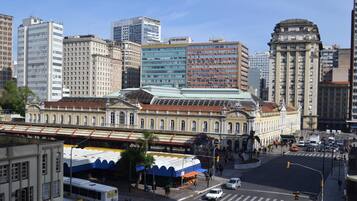 Um edifício histórico com arquitetura clássica, cercado por edifícios modernos e altos.