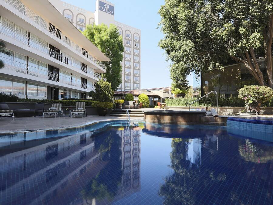 Een buitenzwembad, ligstoelen bij het zwembad