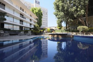 Una piscina al aire libre, sillones reclinables de piscina