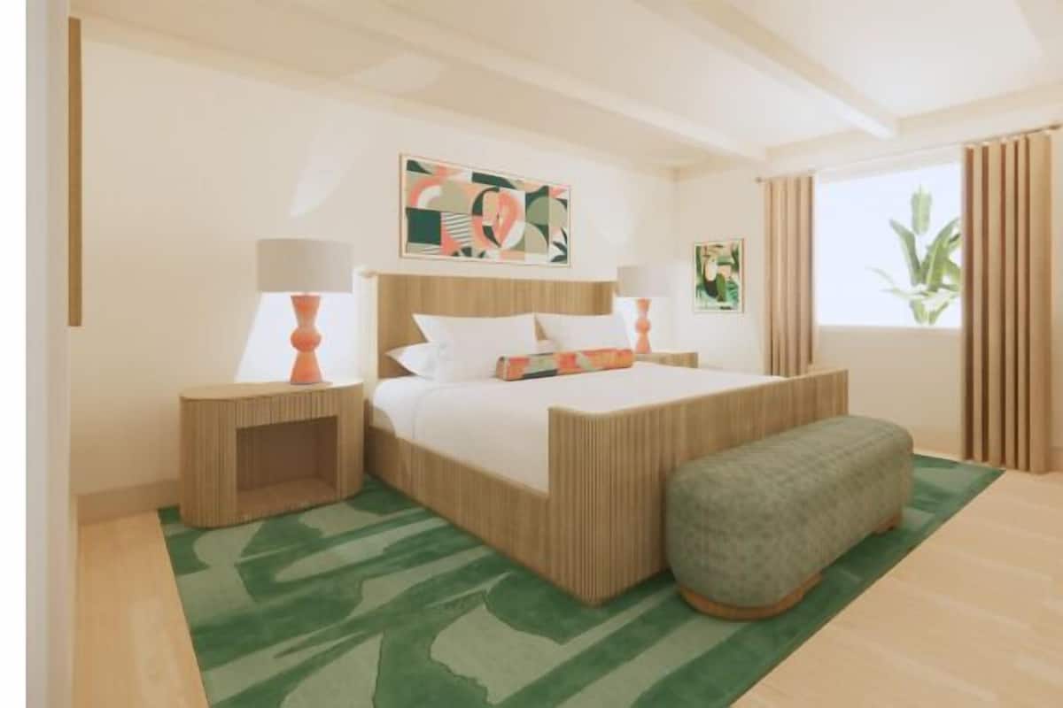 A modern bedroom with a bed, bedside tables, a bench, and artwork on the walls.