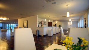 A modern hotel lobby with a reception desk, seating area, and large windows. - Scialì Hotel (Vieste)