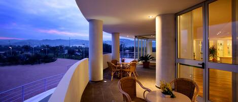 A balcony with wicker furniture and a view of a racetrack.