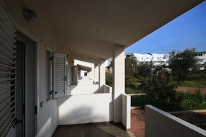 Enjoy a sheltered outdoor space with a tiled floor and lush greenery views.