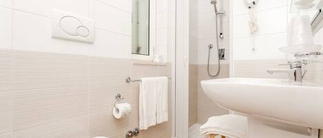 A modern bathroom with a toilet, shower, and sink.