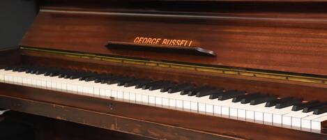 Un piano de cola con una placa que dice "GEORGE RUSSELL".
