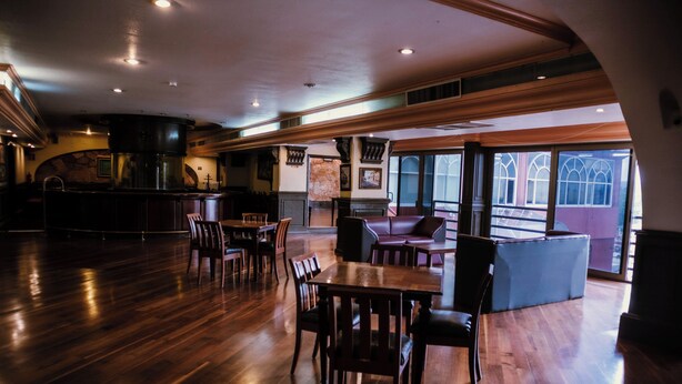 A spacious interior with wooden flooring, a bar area, and seating arrangements. - Hotel María Victoria (Xalapa)