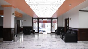 A spacious lobby with a high ceiling, marble flooring, and a central glass door leading outside. - Hotel María Victoria (Xalapa)