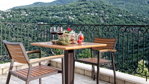 Una mesa con dos sillas en un balcón con vistas a un paisaje montañoso.