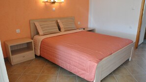 Une chambre à coucher avec un lit, une table de chevet et un luminaire fixé au mur.