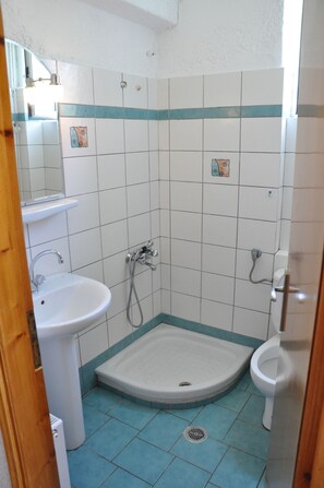 A bathroom with a pedestal sink, a shower, and a toilet. - Villa Annilena (Dorida)