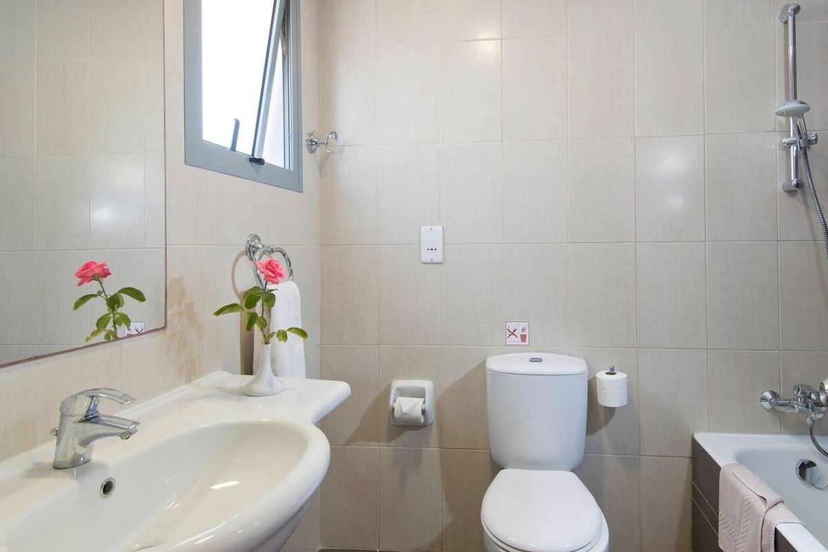 Badkamer | Een bad/douchecombinatie, gratis toiletartikelen, handdoeken