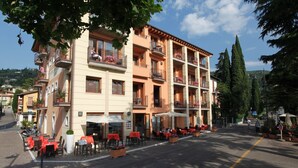 A multi-story hotel with outdoor seating and balconies. - Hotel Lido (Torri del Benaco)