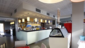 A modern hotel lobby with a bar area, seating, and a vending machine. - Hotel Lido (Torri del Benaco)