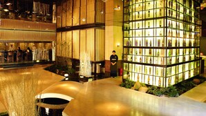 A modern interior with a bar area, a large display of bottles, and a person standing near the display. - Hengfeng Haiyue International Hotel (Shenzhen)