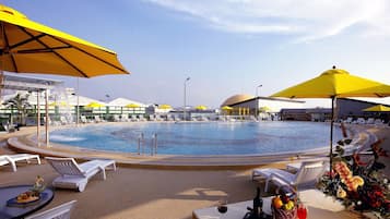 Una piscina al aire libre, sillones reclinables de piscina