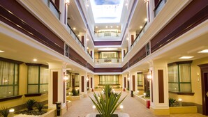 A multi-level atrium with a central garden, multiple floors, and a skylight. - Hengfeng Haiyue International Hotel (Shenzhen)