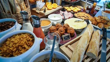 Een buffet met diverse gerechten, waaronder brood, muffins en fruit.