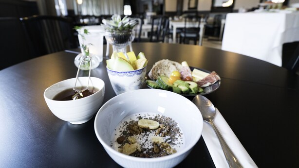 A dining table with bowls of food, a spoon, and a napkin. - Jönköping Vandrarhem - Hostel (Jonkoping)