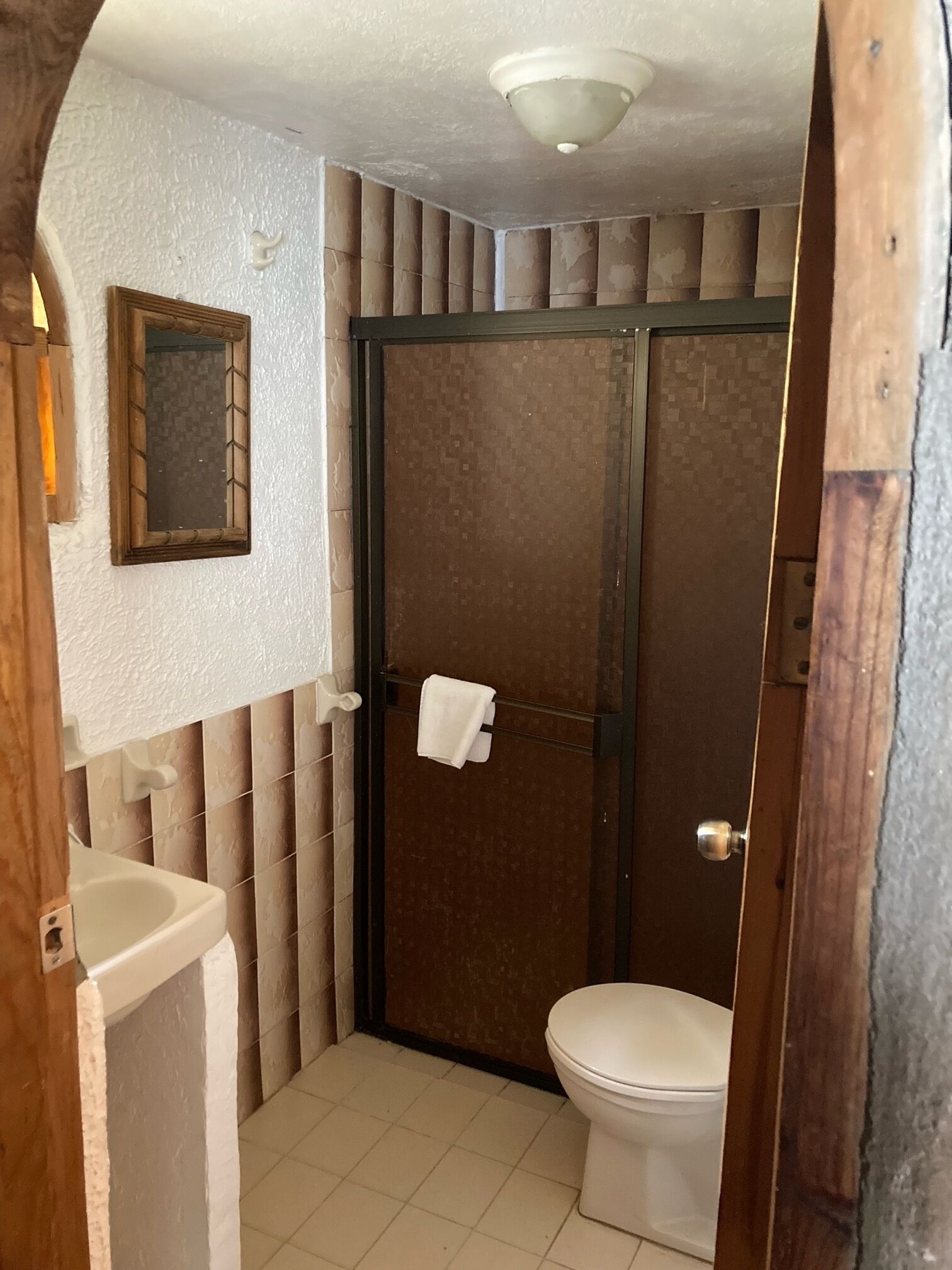 A bathroom with a toilet, a sink, and a shower stall.