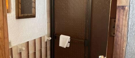 A bathroom with a toilet, a sink, and a shower stall.