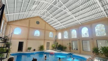 Una piscina techada, sillones reclinables de piscina