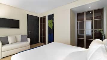 Une chambre à coucher moderne avec un grand lit, un canapé, une armoire et un téléviseur.
