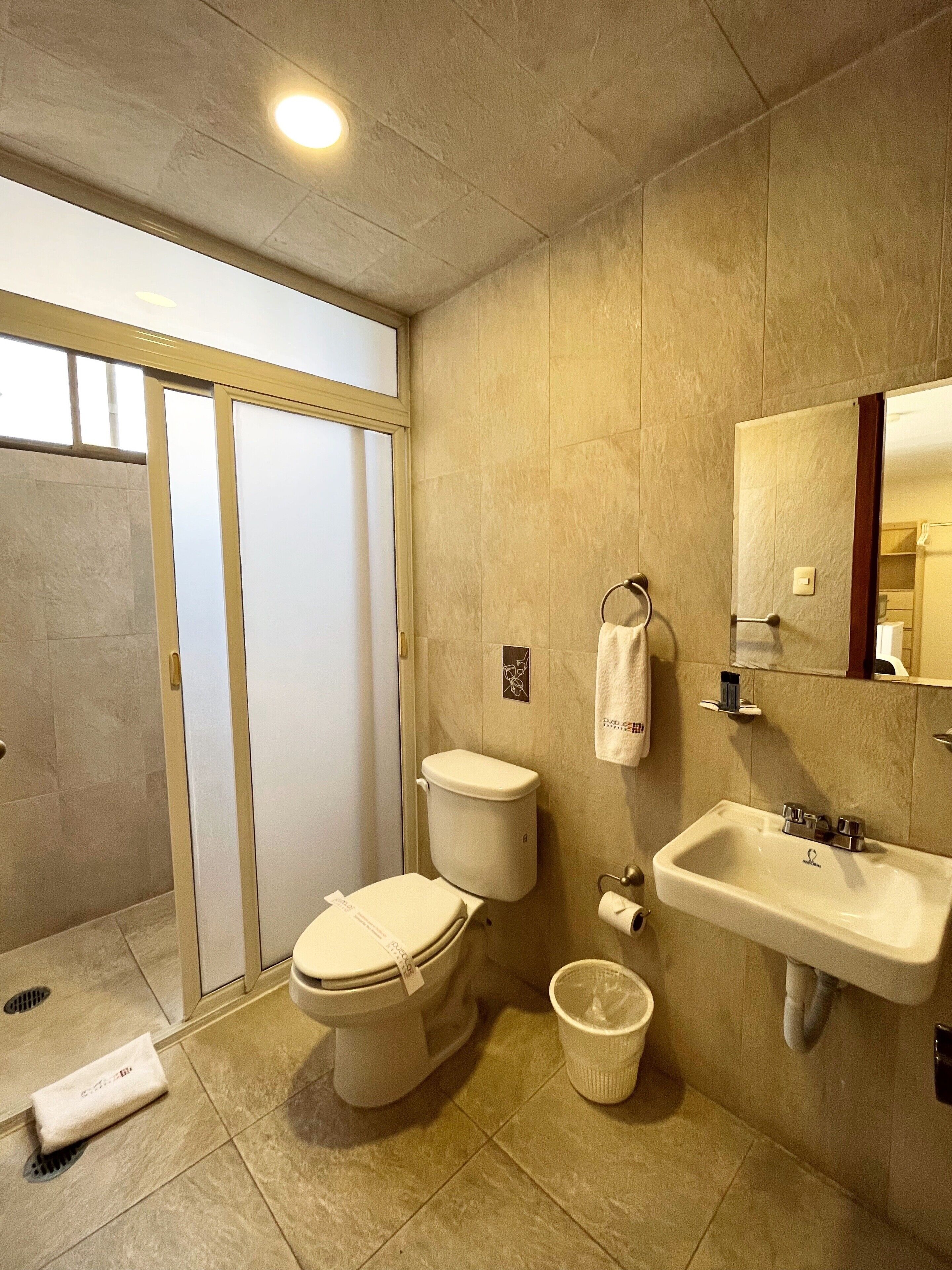A modern bathroom with a toilet, sink, and shower area.