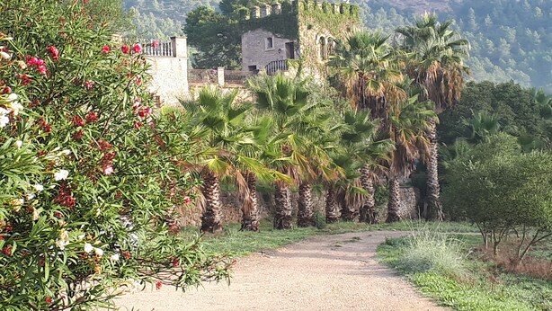 A pathway leading to a stone building with a view of a mountainous landscape. - Finca Hotel Son Pont (Puigpunyent)