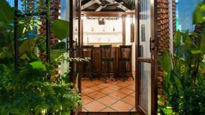 Una zona de bar con suelo de baldosas, sillas de madera y un ventilador de techo.