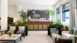 A spacious lobby with a large mural, comfortable seating, and abundant greenery. - Hotel Atwater (Avalon)