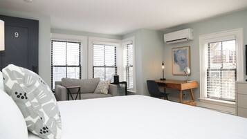 A bedroom with a bed, a desk, a chair, and a couch.