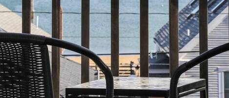 Ein Balkon mit Meerblick, ausgestattet mit einem Tisch und zwei Stühlen.