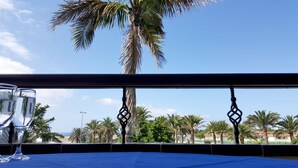 Un balcon offrant une vue dégagée sur les palmiers et la plage.