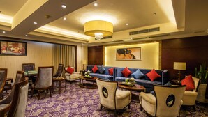 A hotel lobby with a patterned carpet, a blue sofa with red cushions, and a chandelier. - Leeden Hotel Chengdu (Chengdu)