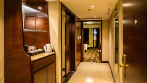 A hotel hallway with a wooden reception desk, a mirror, and a bed in the background. - Leeden Hotel Chengdu (Chengdu)