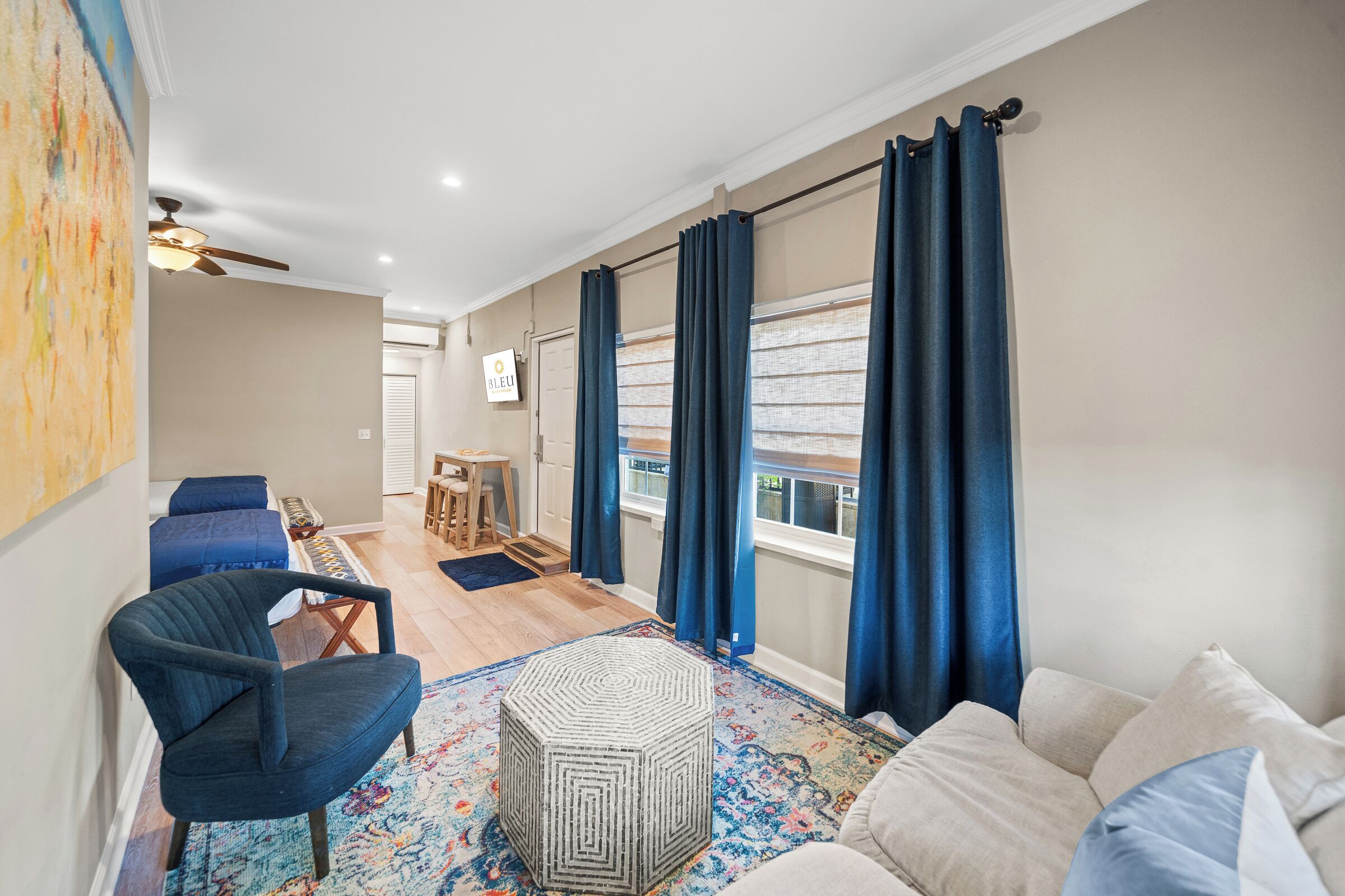 Un salon moderne avec un canapé, des fauteuils, une table basse et un tapis à motifs.