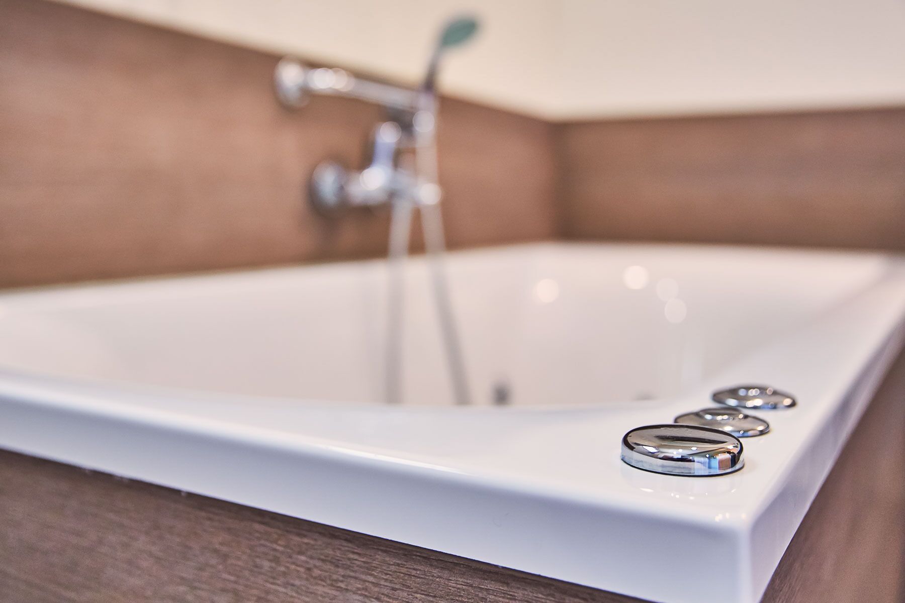 A bathroom with a white bathtub, a faucet, and a mirror.
