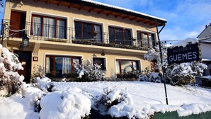A two-story building with a sign reading "Hosteria Guemes" in front. - Hosteria Güemes (San Carlos de Bariloche)