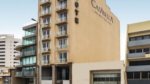 Un hotel llamado CASARILLA ART/BOUTIQUE HOTEL con un diseño moderno, varios balcones y un cielo despejado al fondo.