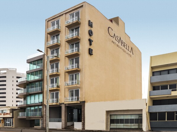 Et hotel kaldet CASARILLA ART/BOUTIQUE HOTEL med moderne design, flere balkoner og en klar himmel i baggrunden.