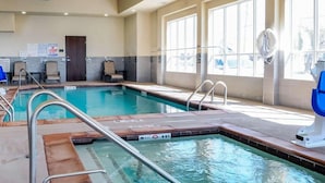 An indoor swimming pool with clear water, marked depth lines, and a lifeguard chair. - Comfort Inn & Suites West Artesia (Artesia)