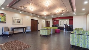 A spacious lobby with a reception desk, seating area, and a kitchen in the background. - Comfort Inn & Suites West Artesia (Artesia)