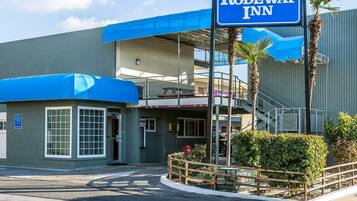 A Rodeway Inn with a blue awning, a covered entrance, and a visible office sign.
