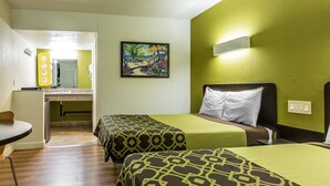 Ett hotellrum med två sängar, ett skrivbord och en stol.