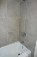 Un baño con bañera, ducha e inodoro.