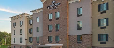 A hotel with a brick facade, multiple windows, and a sign indicating it is Candlewood Suites.