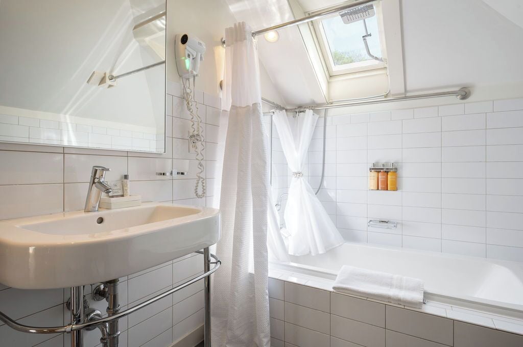 Un baño moderno con un lavabo blanco, una bañera y una zona de ducha.
