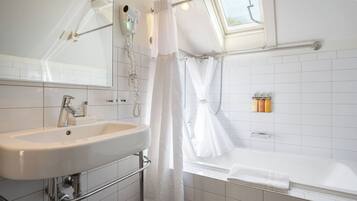 Un baño moderno con un lavabo blanco, una bañera y una zona de ducha.