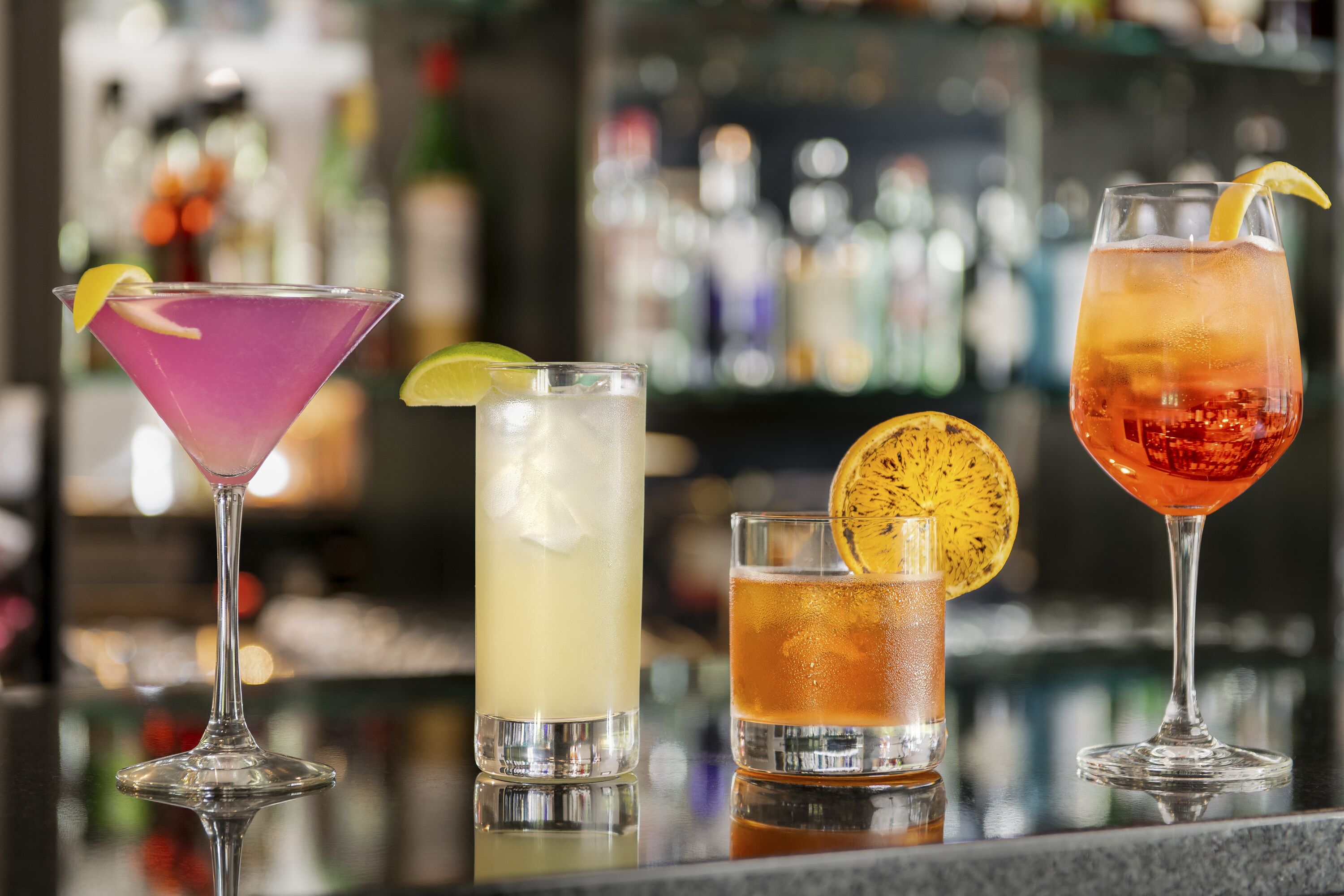 Four different cocktails on a bar counter.