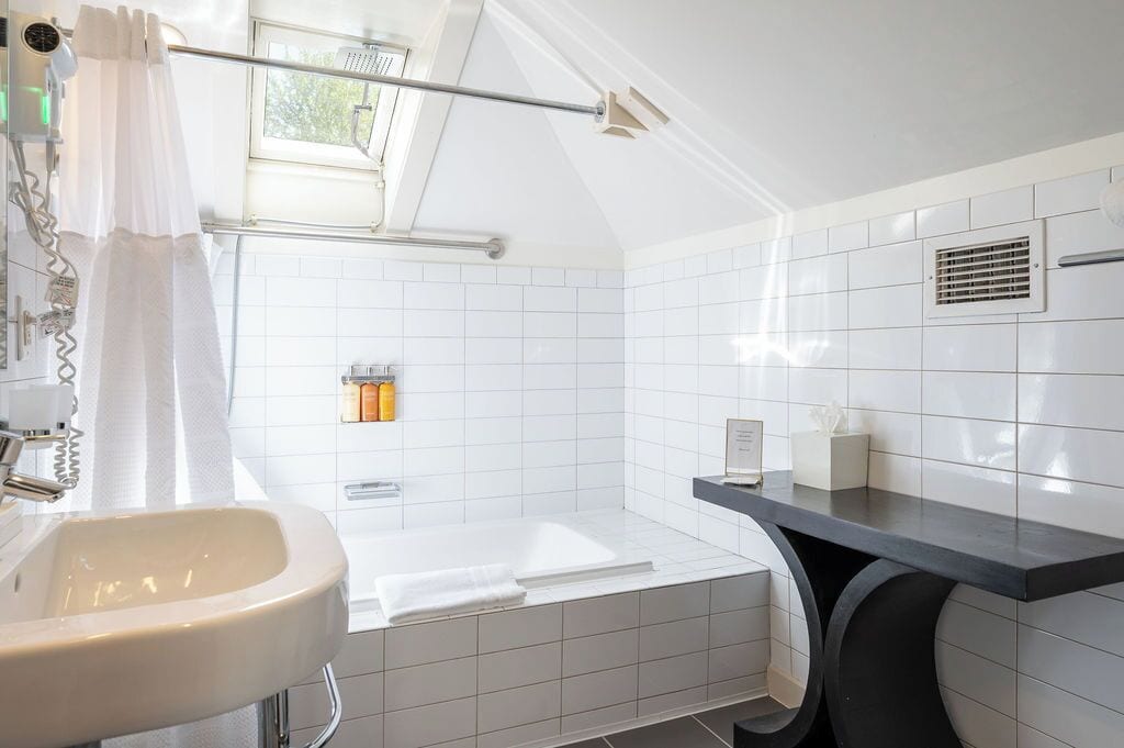 A modern bathroom with a bathtub, a sink, and a shower area.